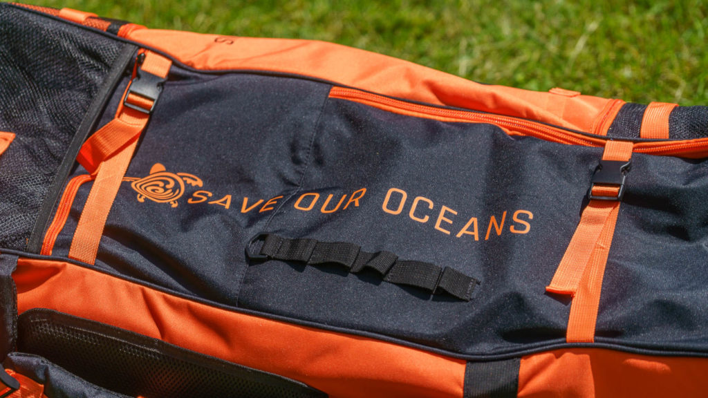 Side of the bag with compression straps, cargo loops, and Save Our Oceans logo.