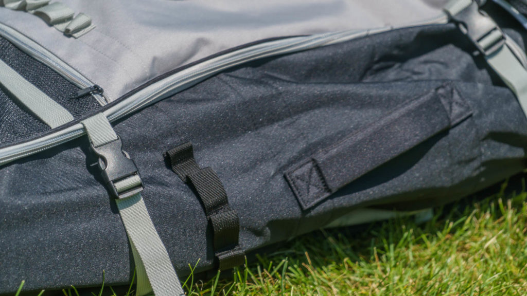 Detail of the side of the bag with thickly padded handle, cargo loops, and 2 compression straps