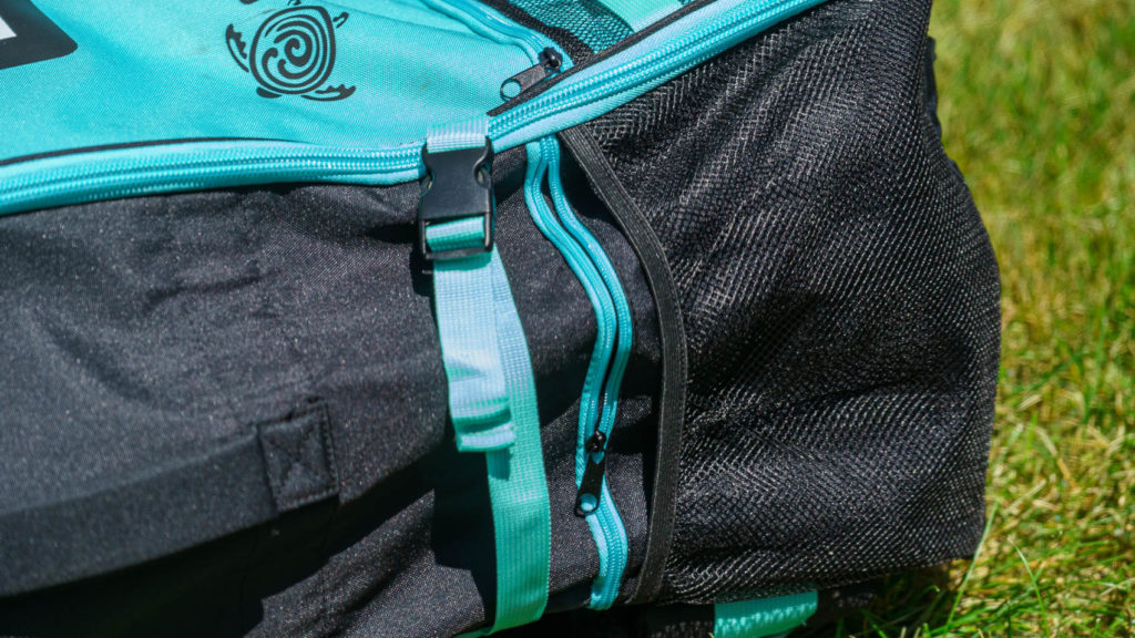 Detail of the side of the bag with zippered pocket, mesh paddle pocket, and compression strap