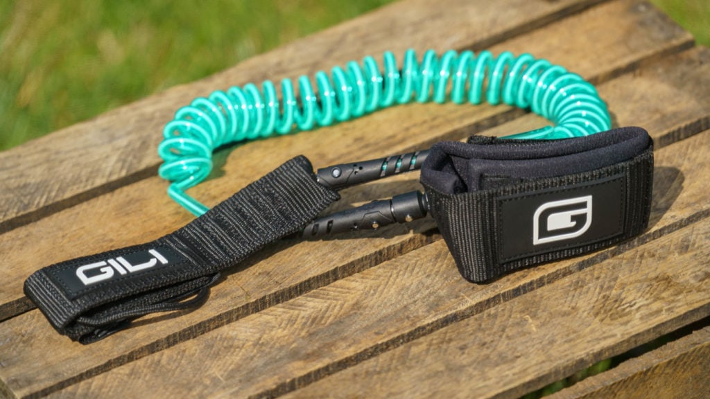 The coiled SUP leash is color matched in teal.